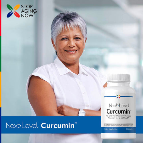 View 7 An older woman smiles with arms crossed next to a bottle of Next Level Curcumin.