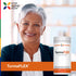 An older woman smiles in a blazer, standing beside a TurmaFLEX bottle.
