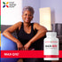 An older woman sits on the floor smiling with an exercise ball beside a MAX-Q10 bottle.