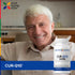 A senior man smiling while holding a CUR-Q10 ULTRA bottle.