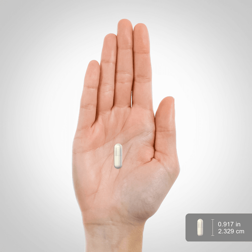 View 2 A white capsule measuring 0.917 inches or 2.329 centimeters, shown on a scale in the image named hand_scale.